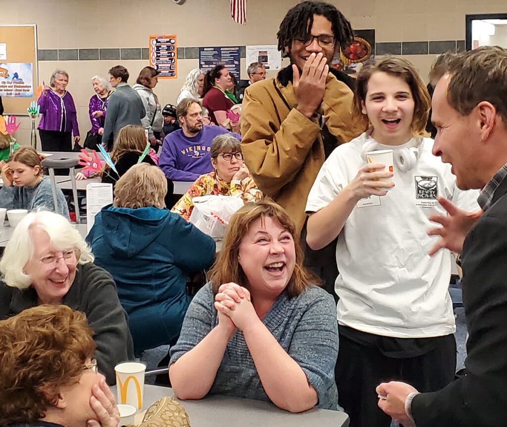 David Farr performing for laughing students in a school cafeteria